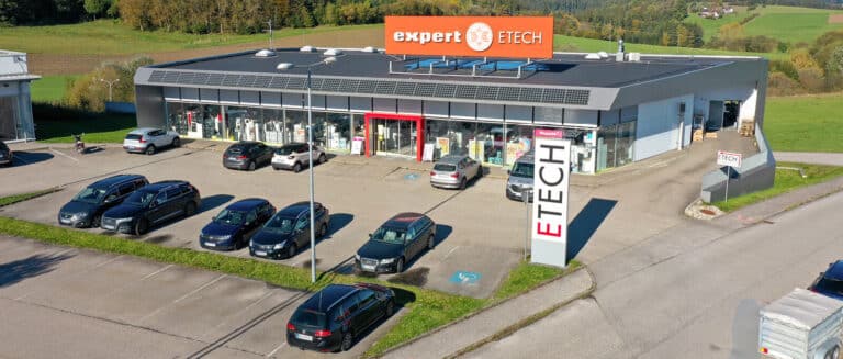 Außenansicht des ETECH-Fachmarkts in Rohrbach mit Parkplatz, Firmenlogo expert ETECH und ETECH-Pylonschild