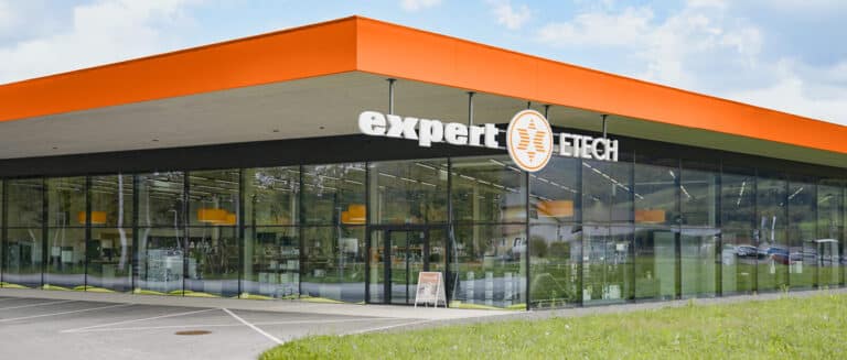 Expert ETECH Filiale Molln-Leonstein – modernes Ladengebäude mit orangefarbenem Dach und Glasfassade