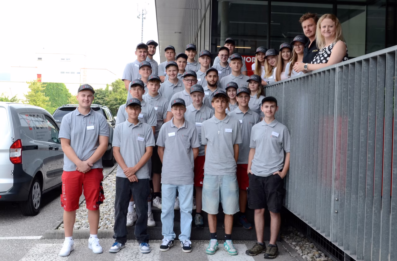 Gruppe von ETECH-Lehrlingen in grauen Polo-Shirts und Caps beim Willkommenstag der Firma ETECH Schmid u. Pachler Elektrotechnik
