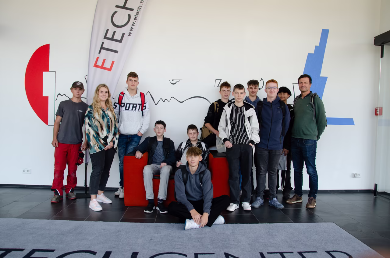 Schülergruppe der PTS Bad Leonfelden zu Besuch im ETECH Center, posierend vor dem ETECH-Logo und Banner