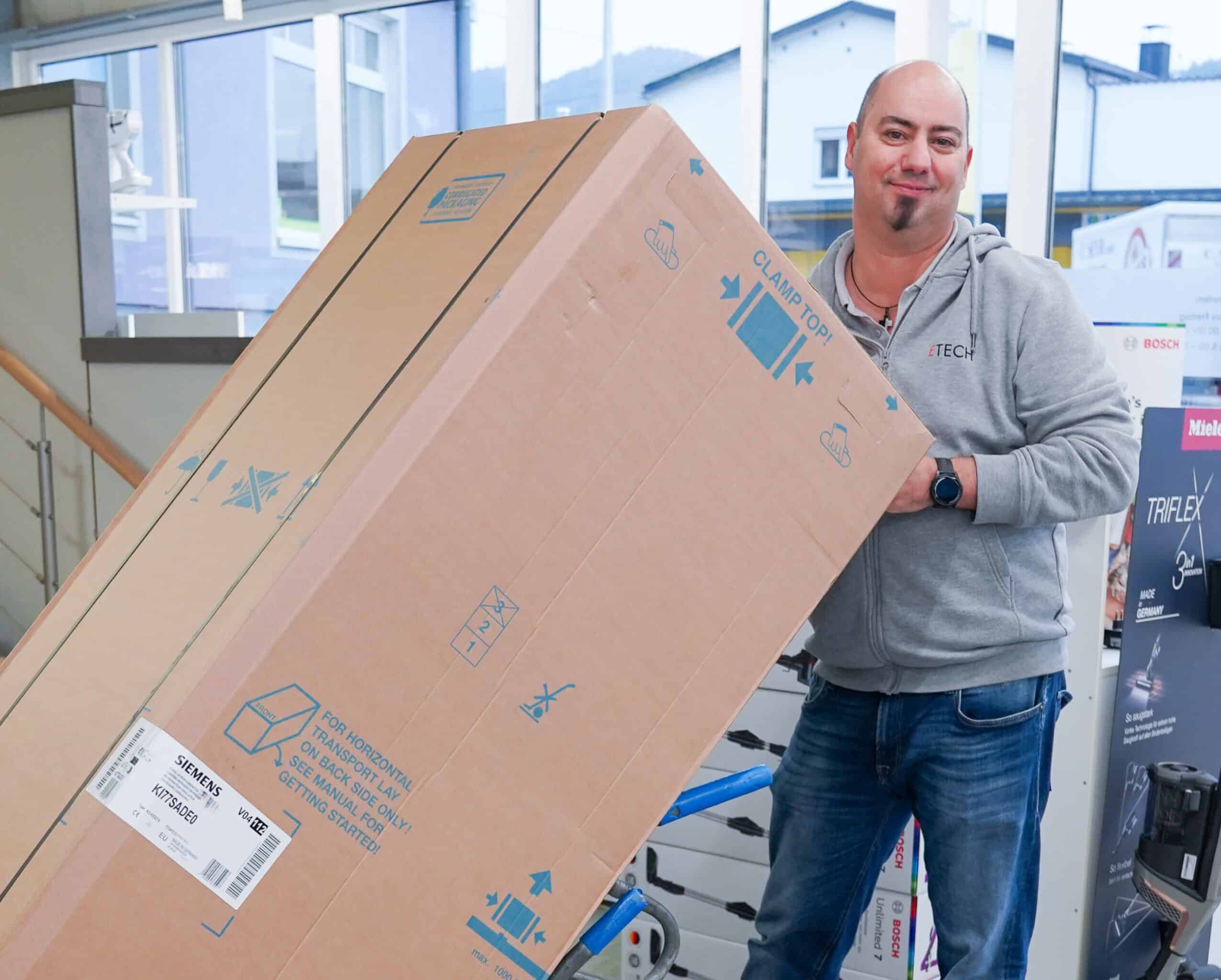 ETECH-Mitarbeiter transportiert große Siemens-Gerätelieferung auf einer Sackkarre im ETECH-Fachhandel
