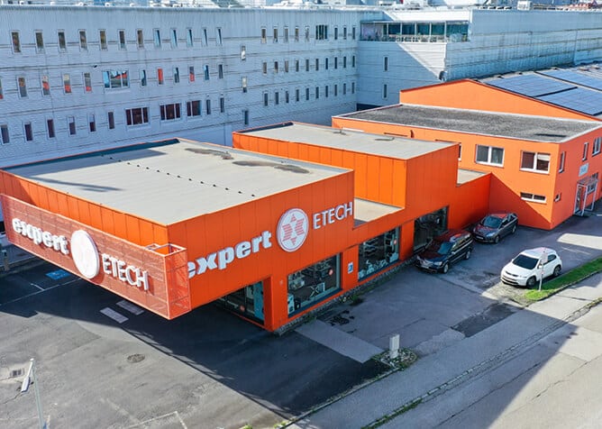 Außenansicht des ETECH-Standorts Linz Urfahr – markantes orangefarbenes Gebäude mit Expert ETECH Beschriftung