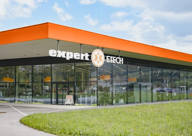 Außenansicht des ETECH-Fachhandelsgeschäfts in Molln-Leonstein mit orangefarbener Fassade und Glasfront