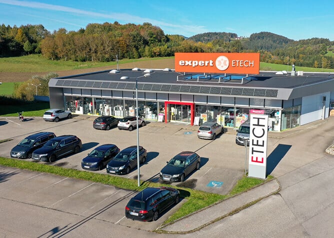 Außenansicht des ETECH-Standorts Rohrbach mit Parkplatz, Schaufensterfront und expert ETECH Beschriftung
